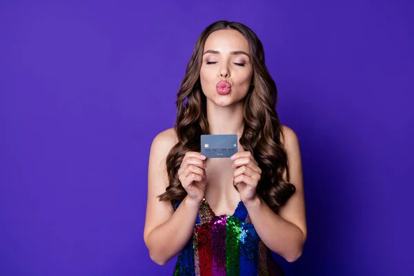 Фото чарівної багатої розкішної дівчини, що тримає дебетову картку, надсилає повітряну спідницю поцілунку, ізольовану на яскраво фіолетовому кольоровому фоні — стокове фото