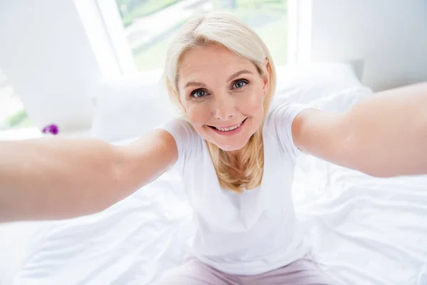 Foto de casa bonita esposa anciana señora tomando selfies radiante sonrisa blogger quedarse en casa dormitorio interior — Foto de Stock