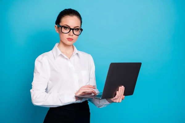 Porträt von schönen attraktiven qualifizierten ernsthaften intelligenten Dame hält in den Händen Laptop isoliert über lebendige blaue Farbe Hintergrund — Stockfoto