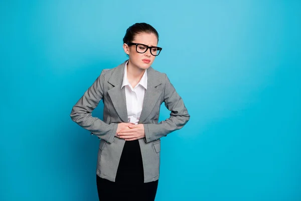 Retrato de mujer enferma atractiva sintiéndose mal tocando el vientre enfermedad de la indigestión del vientre aislado sobre fondo de color azul brillante — Foto de Stock