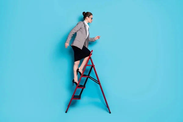Teljes test profil oldalán fotó ambiciózus hölgy mászni létra karrier kopás blézer szoknya elszigetelt kék szín háttér — Stock Fotó