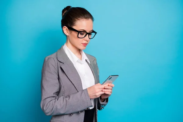 Förvandlat foto av fokuserad agent flicka använda mobiltelefon bära grå kostym kavaj isolerad över blå färg bakgrund — Stockfoto