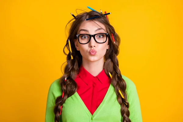 Zdjęcie nerd nastolatek dziewczyna z włosów ołówek wysłać pocałunek powietrza izolowane nad żółtym tle kolor — Zdjęcie stockowe
