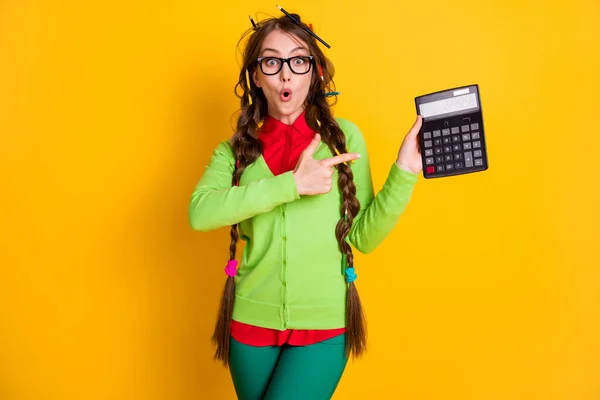 Foto de menina surpreso com penteado desarrumado calculadora dedo indicador isolado no fundo de cor brilhante — Fotografia de Stock