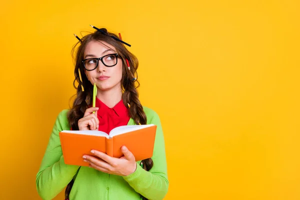 Close-up portrait of attractive minded brainy genius girl writing essay creating solution isolated over bright yellow color background — Stock Photo, Image