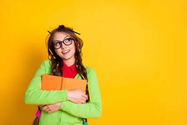 Retrato de muito funky sonhador alegre criativo intelectual menina abraçando livro de exercícios pensamento cópia espaço isolado sobre brilhante cor amarela fundo — Fotografia de Stock