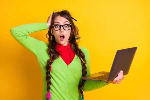 Ritratto di attraente funky stupito genio ragazza tenendo in mano laptop anno accademico isolato su sfondo di colore giallo brillante — Foto Stock