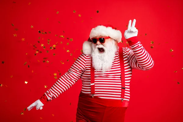 Foto do aposentado avô barba cinza show v-sign dança despreocupada boca aberta desgaste santa x-mas traje suspensórios luvas de vidro solar listrado camisa tampa isolado cor vermelha fundo — Fotografia de Stock