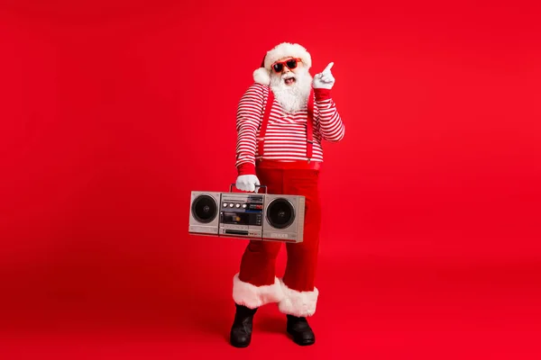 Pleine longueur taille du corps vue de son il il beau beau joyeux joyeux gai comique père noël enfantin ayant plaisir fête fête écoute stéréo isolé lumineux vif éclat vibrant fond de couleur rouge — Photo