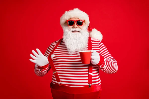 Portret jego ładny przystojny atrakcyjny wesoły wesoły pewny Santa ojciec pije ajerkoniak ciągnąc szelki zabawy odizolowane jasny żywy połysk żywy czerwony kolor tło — Zdjęcie stockowe