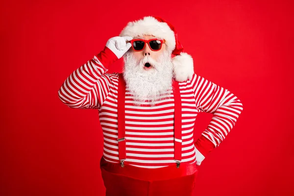 Retrato dele ele bonito bonito espantado maravilhado cinza-haired Santa vestindo óculos de sol tocantes inverno incrível pechincha isolado sobre brilhante vívido brilho vibrante cor vermelha fundo — Fotografia de Stock