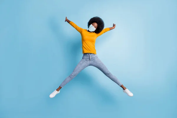 Foto retrato corpo inteiro de mulher pulando se espalhando como estrela usar máscara médica isolada no fundo de cor azul pastel — Fotografia de Stock