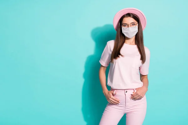 Foto de menina bonita colocar as mãos no bolso olhar sobre o desgaste da câmera máscara médica facial isolado cor turquesa fundo — Fotografia de Stock