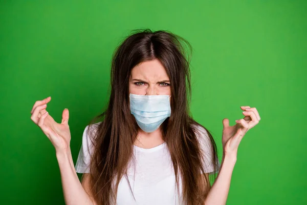 Foto de menina com raiva bonita usar máscara facial roupa casual tem cabelo mau estado braços para cima isolado cor verde fundo — Fotografia de Stock