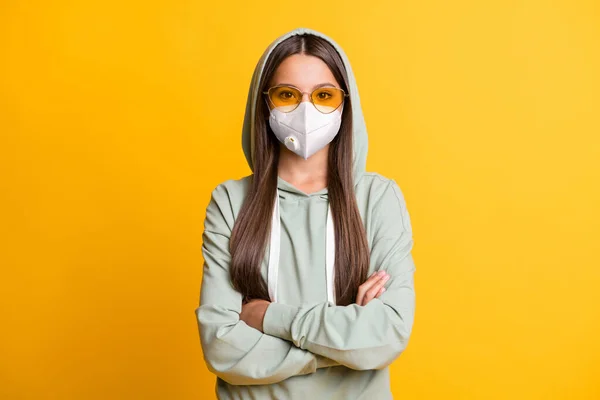 Portret van casual brunette meisje gevouwen armen dragen witte ademhalingsmasker geïsoleerd op gele kleur achtergrond — Stockfoto