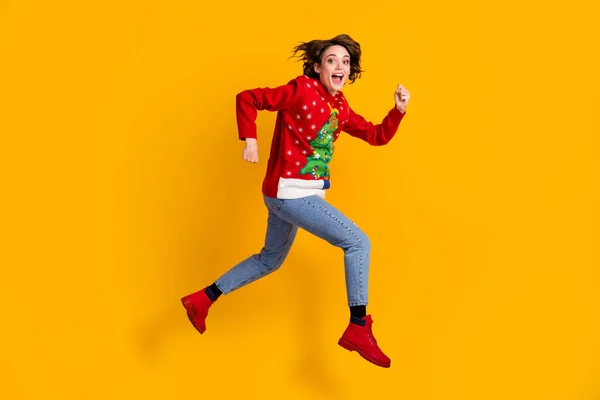 Ganzes Profil Seite Foto von aufgeregten Mädchen springen laufen Eile x-mas Tradition Rabatte tragen Weihnachtsbaum Pullover Jeans isoliert hell Glanz Farbe Hintergrund — Stockfoto