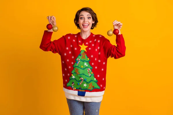 Photo of amazed positive girl hand decorate christmas tree balls baubles wear theme party sweater denim jeans isolated over bright shine color background — Stock Photo, Image