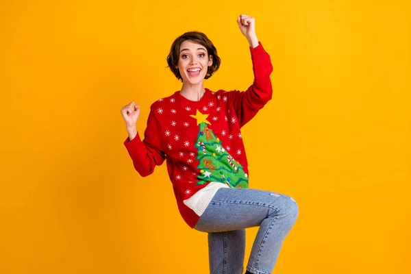 Photo of excited girl in christmas tree decor pullover sweater denim jeans raise fists x-mas newyear lottery win isolated over bright shine color background — Stock Photo, Image
