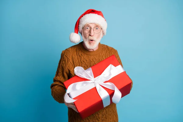 Portret van hem hij mooie aantrekkelijke verbaasd vrolijke baard grijs-harige Santa vader houden in handen geven u december giftbox verkoop pruik lippen geïsoleerd over blauw pastel kleur achtergrond — Stockfoto