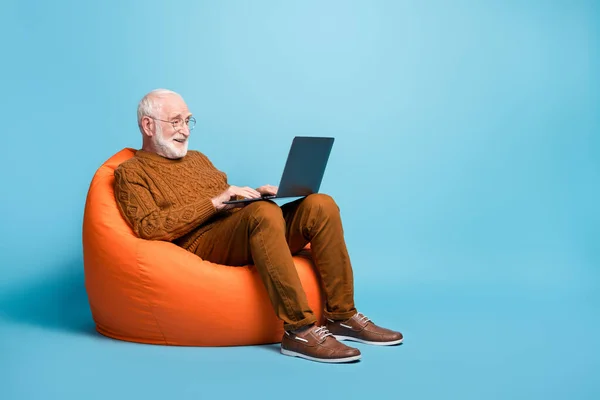Portret jego ładny atrakcyjny koncentruje brodaty siwy mężczyzna siedzi w torbie krzesło za pomocą laptopa pisanie e-maila przeglądanie web wi-fi odizolowany nad niebieskim pastelowym tle — Zdjęcie stockowe