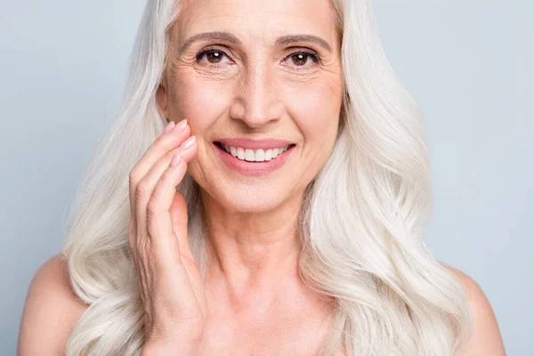 Close up foto da bela mulher idosa cinza senhora cabelo aplicando diária noite creme bochecha isolado cinza cor fundo — Fotografia de Stock