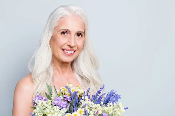 Çekici, çıplak, emekli bir kadının fotoğrafı büyük bir demet yabani çiçek tutar. Tazelik konsepti izole edilmiş gri arka plan. — Stok fotoğraf