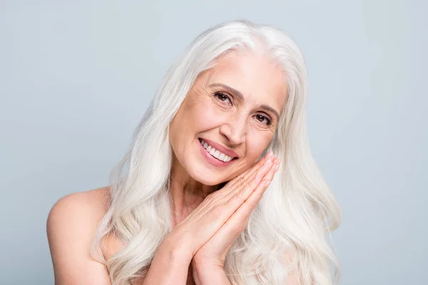 Close up foto de bela senhora de cabelo branco envelhecido aplicar diariamente noite creme braços perto da bochecha isolado fundo de cor cinza — Fotografia de Stock