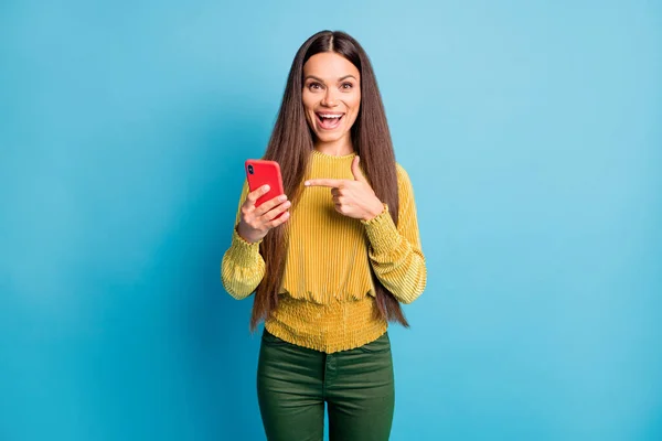 Foto ritratto di donna che tiene il telefono in una mano che punta il dito verso di esso isolato su sfondo di colore blu pastello — Foto Stock