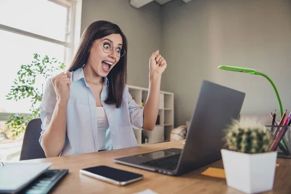Zdjęcie szalonej podekscytowanej dziewczyny podnieść pięści otwarte usta wygląd ekran laptop nosić okulary koszulę w biurze w domu w pomieszczeniach — Zdjęcie stockowe
