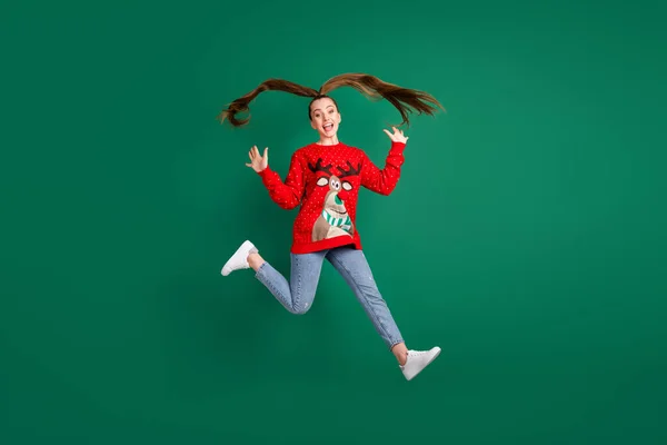 Full längd foto av galna funky ganska söt dam hoppa hög jul fest hälsa vänner händelse kör dörr sätt kram bära ren röd ful prydnad tröja jeans isolerad grön färg bakgrund — Stockfoto