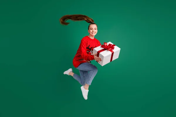 Foto de perfil de tamaño completo de salto de señora bonita alta fiebre x-mas fiesta familia regalo grande regalo emocionado cumplir con los padres tradición desgaste rojo feo suéter jeans zapatos aislados color verde fondo —  Fotos de Stock