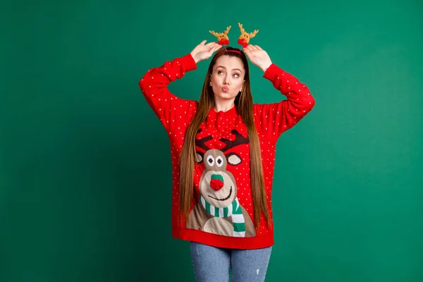 Photo of attractive cute funky lady long brown tail pouted lips playing headband deer horns decor christmas party preparations wear red ornament ugly pullover isolated green color background — Stock Photo, Image