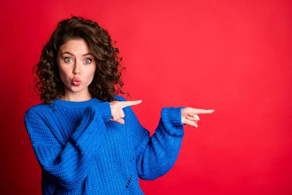 Photo of lovely pretty lady curly hairstyle direct indicate forefingers empty space lips pouted childish staring look wear blue knitted sweater pullover isolated red color background — Stock Photo, Image