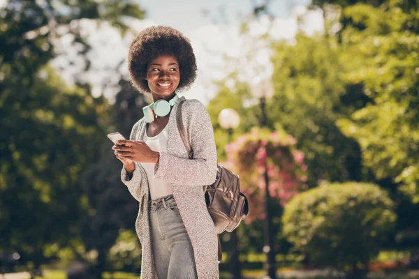 Foto van positieve afro-Amerikaanse meisje gebruik maken van smart phone dragen rugzak vest in de zomer centrum bossen — Stockfoto