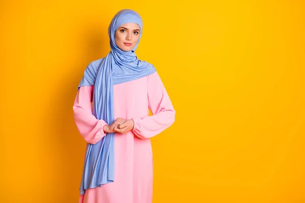 Portrait of attractive fashionable peaceful modest muslimah wearing cosy dress isolated over bright yellow color background — Stock Photo, Image