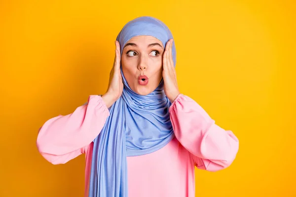 Close-up retrato de muslimah muito preocupado vestindo hijab olhando para o lado incrível notícias pout lábios wow isolado no fundo cor amarela brilhante — Fotografia de Stock