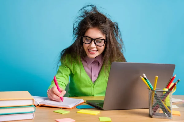 Primer plano retrato de buena chica morena atractiva inteligente alegre enfocado haciendo la tarea utilizando el ordenador portátil aislado sobre fondo de color azul brillante — Foto de Stock