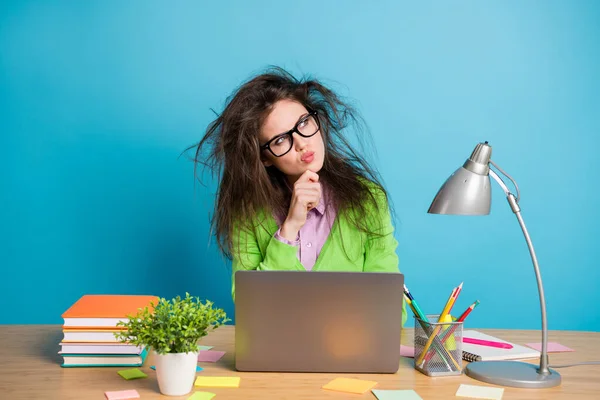 Foto van pensive meisje zitten tafel werk laptop kijken copyspace denken dragen groen shirt geïsoleerd over blauwe kleur achtergrond — Stockfoto