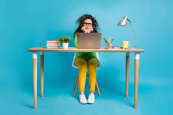 Retrato dela ela agradável atraente maçante menina fazendo trabalho em casa tarefa sentado na frente de laptop isolado sobre brilhante azul cor de fundo — Fotografia de Stock