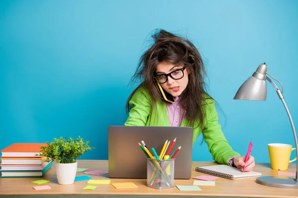 Retrato de niña sobrecargada de trabajo de mesa de sentarse portátil escribir nota libro de vestir camisa verde aislado sobre fondo de color azul —  Fotos de Stock