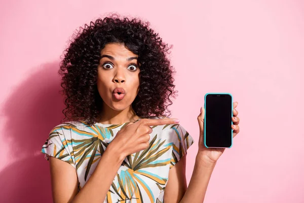 Retrato fotográfico de una mujer conmocionada apuntando con el dedo al teléfono con espacio en blanco aislado sobre fondo de color rosa pastel — Foto de Stock