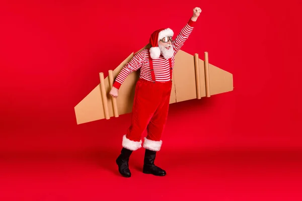 Güzel, neşeli, sakallı, jet kanatlı Noel Baba 'nın boy boy boy görüntüsü. Hava kanatları takan havayolu şirketi hediyeleri dağıtıyor. İzole edilmiş, parlak, parlak, kırmızı arka plan renkleri var. — Stok fotoğraf