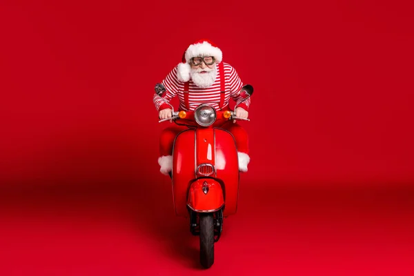 Portret van zijn hij knappe geconcentreerde geconcentreerd baard Santa vader rijden bromfiets Noordpool levering reis snelle snelheid haast reis geïsoleerde helder levendige glans levendige rode kleur achtergrond — Stockfoto