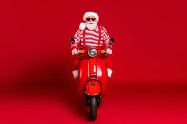 Retrato dele ele bonito sério barbudo Papai Noel hipster equitação ciclomotor Pólo Norte viagem maneira viajante isolado brilhante brilhante brilho vibrante cor vermelha fundo — Fotografia de Stock