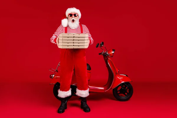 Pełna długość zdjęcie emeryta dziadek motorower trzymać pudełka pizzy otwarte usta późno omg nosić Santa x-mas kostium szelki sunglass buty w paski koszula czapka odizolowany czerwony kolor tło — Zdjęcie stockowe