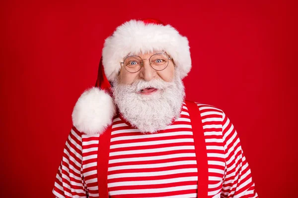 Foto de pensionista anciano alegre sonriente preparar ciervo trineo presenta trabajo navidad vacaciones desgaste traje de santa tirantes gafas rayas camisa diadema aislado color rojo fondo — Foto de Stock