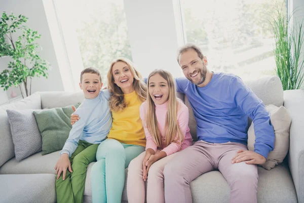 Foto de harmonia aconchegante família sentar sofá mamãe papai dois filhos menino menina assistir desenhos animados engraçados em casa dentro de casa — Fotografia de Stock