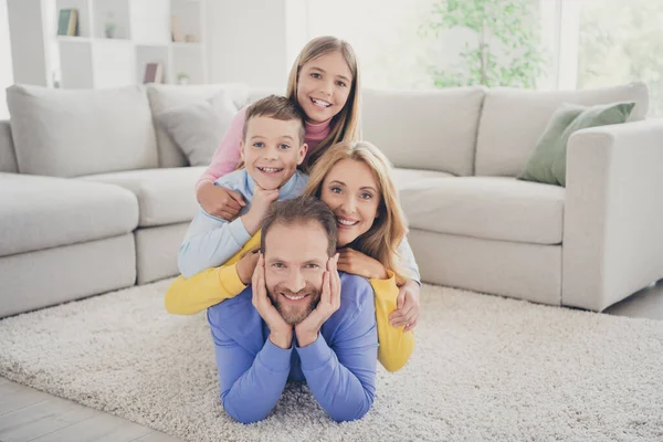 Full size photo of idyllic family mommy and two kids boy girl lying on daddy carpet in house indoors — Stock Photo, Image