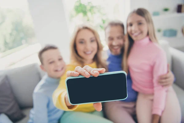 Zdjęcie ludzi rodziny mamusia tatuś i dwójka dzieci chłopiec dziewczyna zrobić selfie na ekranie dotykowym smartfona w domu wewnątrz — Zdjęcie stockowe