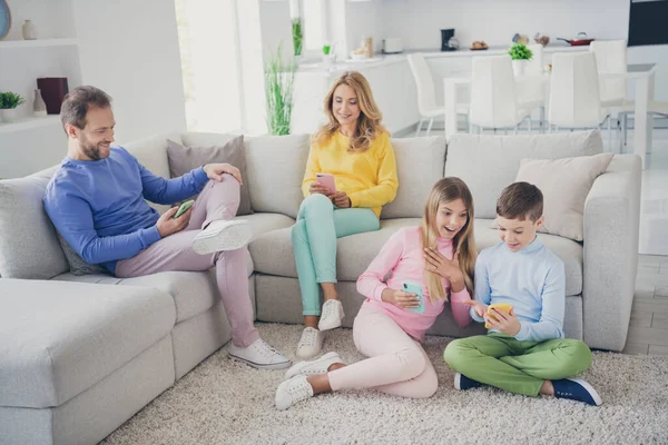 Full storlek foto av familj människor mamma pappa två små barn sitta golv soffa läsa sociala nätverk chockad nyheter i huset inomhus — Stockfoto
